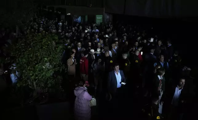 Spectators roam inside the Madrid Open tennis tournament venue during a general blackout in Madrid, Monday, April 28, 2025. (AP Photo/Manu Fernandez)