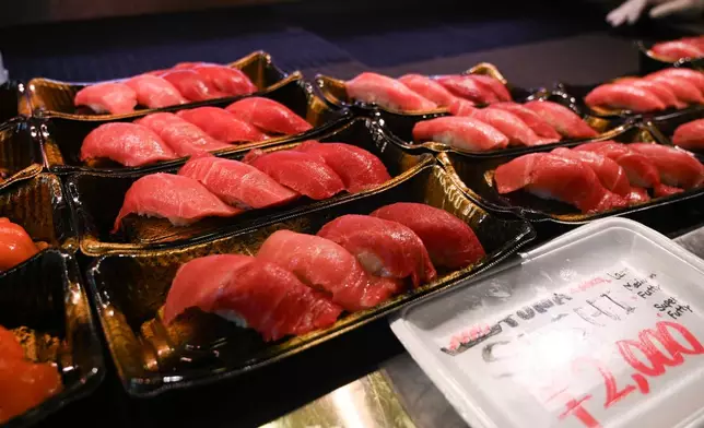 A display shows tuna sushi sets being sold at a market stall in Tokyo, Japan, Thursday, April 10, 2025. (AP Photo/Ayaka McGill)