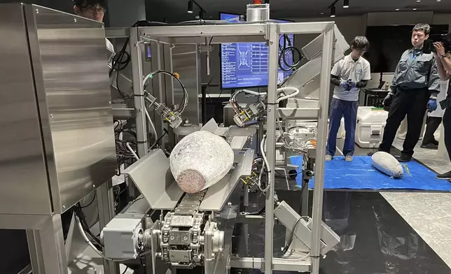 Tuna goes into a special machine called Sonofai that can detect the amount of fattiness in the fish meat by using ultrasound, sensors and AI at a Fujitsu facility in Kawasaki, Japan Wednesday, April 9, 2025. (AP Photo/Yuri Kageyama)