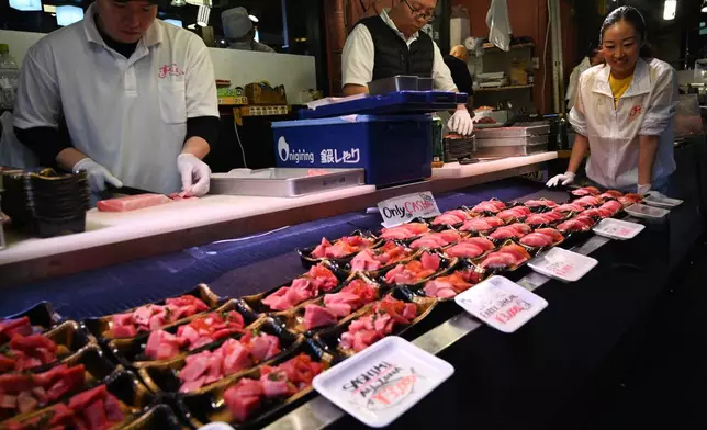 A stall sells tuna sushi sets at Tsukiji market in Tokyo Thursday, April 10, 2025. (AP Photo/Ayaka McGill)