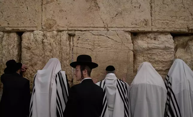 Covered in prayer shawls, Jewish men of the Cohanim Priestly caste participate in a blessing during the holiday of Passover, at the Western Wall, the holiest site where Jews can pray, in the Old City of Jerusalem, Tuesday, April 15, 2025. (AP Photo/Leo Correa)