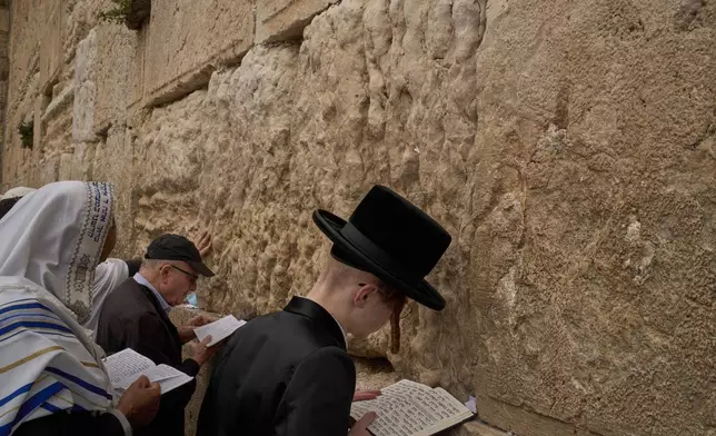 An ultra-Orthodox Jewish young man prays as he participates in a blessing during the holiday of Passover, at the Western Wall, the holiest site where Jews can pray, in the Old City of Jerusalem, Tuesday, April 15, 2025. (AP Photo/Leo Correa)
