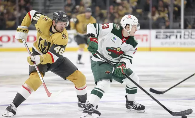 Minnesota Wild center Marco Rossi (23) skates past Vegas Golden Knights center Tomas Hertl (48) during the second period in Game 1 of an NHL hockey Stanley Cup first-round playoff series Sunday, April 20, 2025, in Las Vegas. (AP Photo/Ian Maule)