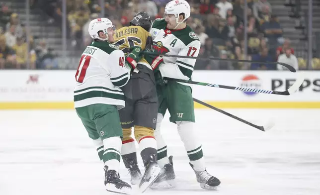 Minnesota Wild center Gustav Nyquist (41) and left wing Marcus Foligno (17) check Vegas Golden Knights right wing Keegan Kolesar (55) during the first period in Game 1 of an NHL hockey Stanley Cup first-round playoff series Sunday, April 20, 2025, in Las Vegas. (AP Photo/Ian Maule)