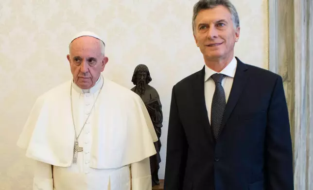 FILE - Pope Francis and Argentina's president Mauricio Macri pose for a picture during a private audience at the Vatican, Feb. 27, 2016. (L'Osservatore Romano/Pool Photo via AP)