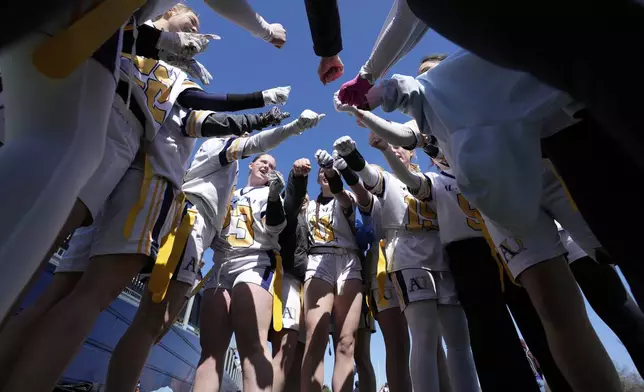 Augustana University players huddle before a women's college flag football game against Concordia University, St. Paul, April 7, 2025, in St. Paul. Minn. (AP Photo/Abbie Parr)