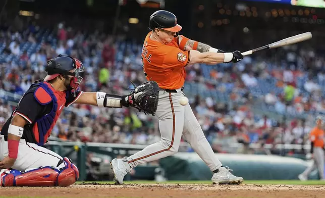 Baltimore Orioles' Tyler O'Neill, right, strikes out swinging in front of Washington Nationals catcher Keibert Ruiz (20) during the fourth inning of a baseball game, Wednesday, April 23, 2025, in Washington. (AP Photo/Stephanie Scarbrough)