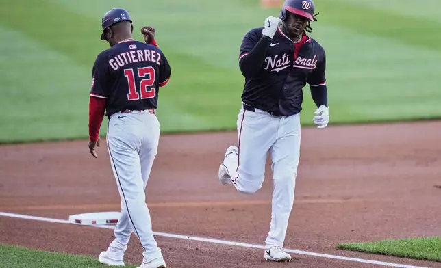 Washington Nationals' Josh Bell, right, celebrates with third base coach Ricky Gutierrez (12) after hitting a two-run home run during the first inning of a baseball game against the Baltimore Orioles, Wednesday, April 23, 2025, in Washington. (AP Photo/Stephanie Scarbrough)