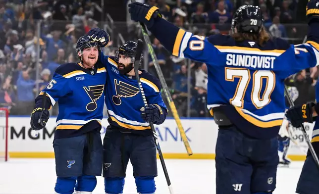 St. Louis Blues' Tyler Tucker, left, celebrates with teammates after scoring against the Winnipeg Jets during the second period in Game 4 of an NHL hockey first-round playoff series Sunday, April 27, 2025, in St. Louis. (AP Photo/Connor Hamilton)