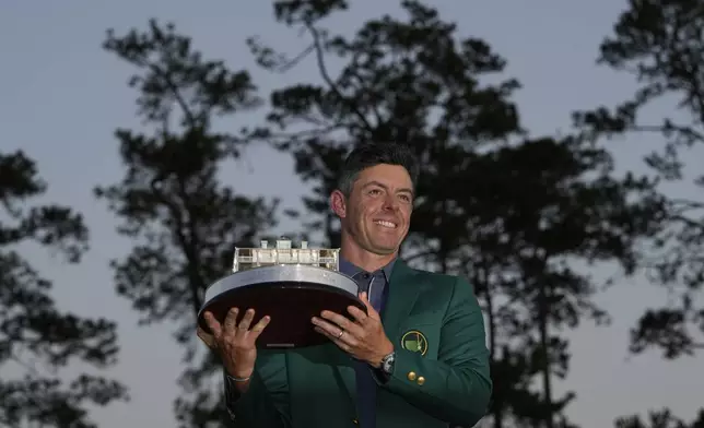 Winner Rory McIlroy, of Northern Ireland, holds the trophy at the Masters golf tournament, Sunday, April 13, 2025, in Augusta, Ga. (AP Photo/David J. Phillip)