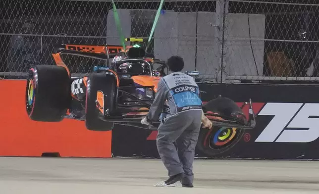 McLaren driver Lando Norris' car is carried out of the track after crashing during the qualifying session ahead of the Formula One Saudi Arabian Grand Prix at the Jeddah Corniche Circuit in Jeddah, Saudi Arabia, Saturday, April 19, 2025. (AP Photo/Altaf Qadri)