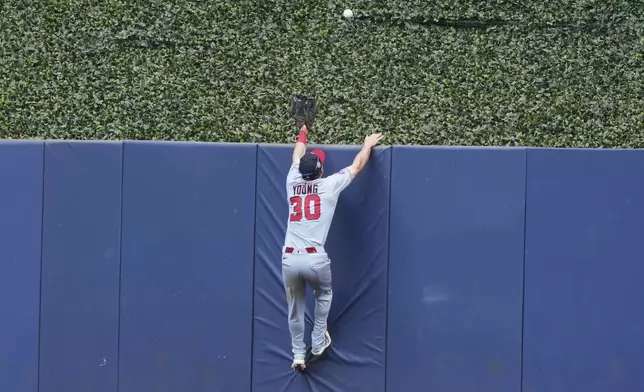 Washington Nationals center fielder Jacob Young (30) can't get to a ball hit by Miami Marlins' Matt Mervis for a three-run home run during the seventh inning of a baseball game, Sunday, April 13, 2025, in Miami. (AP Photo/Lynne Sladky)