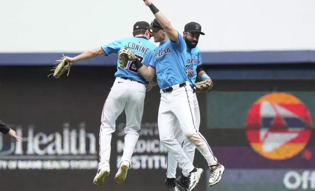Miami Marlins left fielder Griffin Conine, left, right fielder Kyle Stowers, center, and center fielder Derek Hill, right, celebrate after the Marlins defeated the Washington Nationals in a baseball game, Sunday, April 13, 2025, in Miami. (AP Photo/Lynne Sladky)