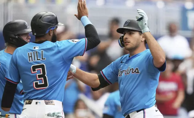 Miami Marlins' Matt Mervis, right, is met by Derek Hill (3) after hitting a three-run home run during the seventh inning of a baseball game against the Washington Nationals, Sunday, April 13, 2025, in Miami. (AP Photo/Lynne Sladky)