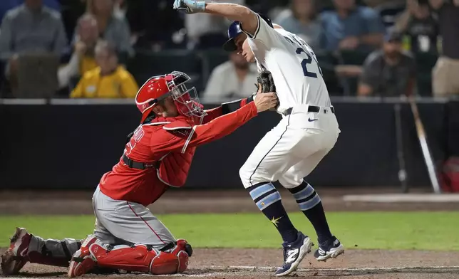 Los Angeles Angels catcher Travis d'Arnaud (25) tags out Tampa Bay Rays' Jake Mangum (28) as he tries to score on a fielder's choice by Yandy Díaz during the ninth inning of a baseball game Tuesday, April 8, 2025, in Tampa, Fla. (AP Photo/Chris O'Meara)