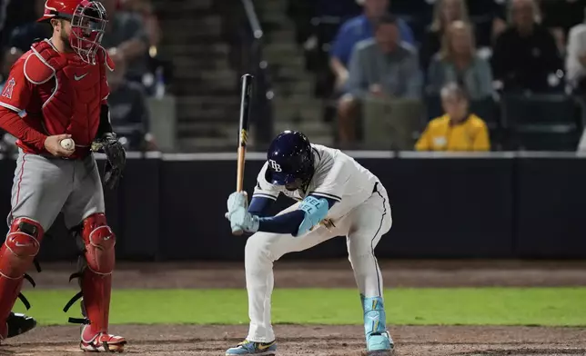 Tampa Bay Rays' Christopher Morel, center, slams his bat after striking out against Los Angeles Angels pitcher Brock Burke during the eighth inning of a baseball game Tuesday, April 8, 2025, in Tampa, Fla. (AP Photo/Chris O'Meara)