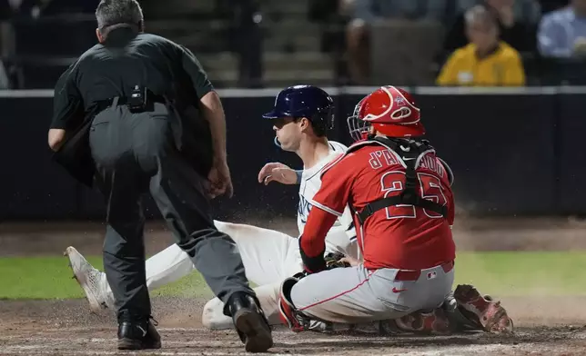 Los Angeles Angels catcher Travis d'Arnaud (25) tags out Tampa Bay Rays' Kameron Misner while trying to score on a fielder's choice by Jake Mangum during the seventh inning of a baseball game Tuesday, April 8, 2025, in Tampa, Fla. (AP Photo/Chris O'Meara)