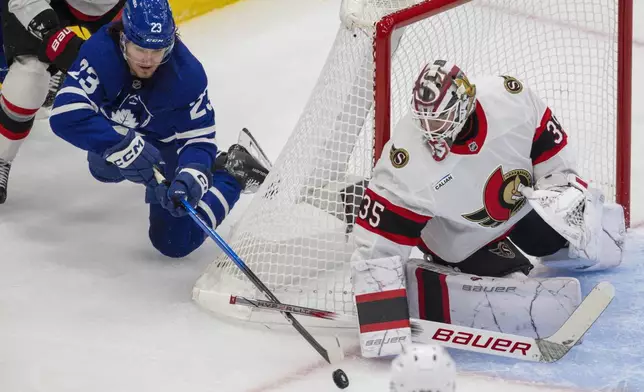 Toronto Maple Leafs' Matthew Knies (23) falls on a wraparound attempt against Ottawa Senators goaltender Linus Ullmark (35) during first period NHL playoff action in Toronto on Tuesday, April 22, 2025. (Nick Iwanyshyn/The Canadian Press via AP)
