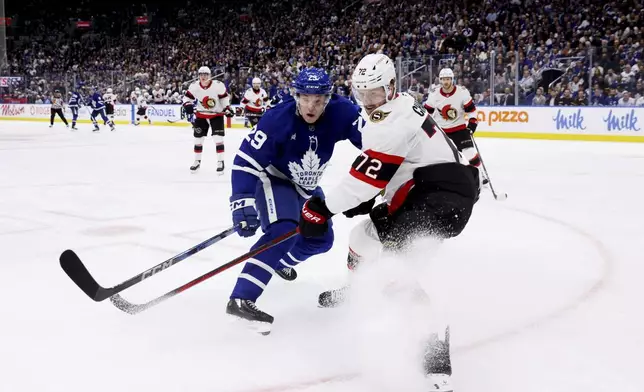 Toronto Maple Leafs' Pontus Holmberg (29) and Ottawa Senators' Thomas Chabot (72) battle for the puck during second period NHL playoff action in Toronto, on Tuesday, April 22, 2025. (Cole Burston/The Canadian Press via AP)