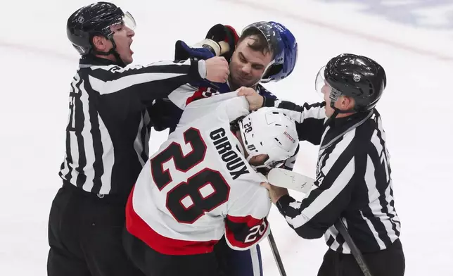 Referees break up a fight between Toronto Maple Leafs' Scott Laughton (24) and Ottawa Senators' Claude Giroux (28) during first period NHL playoff action in Toronto on Tuesday, April 22, 2025. (Cole Burston/The Canadian Press via AP)
