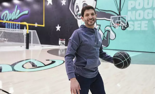 Dude Perfect Chief Executive Officer Andrew Yaffe plays with a basketball as he gives an interview at their new headquarters in Frisco, Texas, Wednesday, Feb. 19, 2025. (AP Photo/Tony Gutierrez)