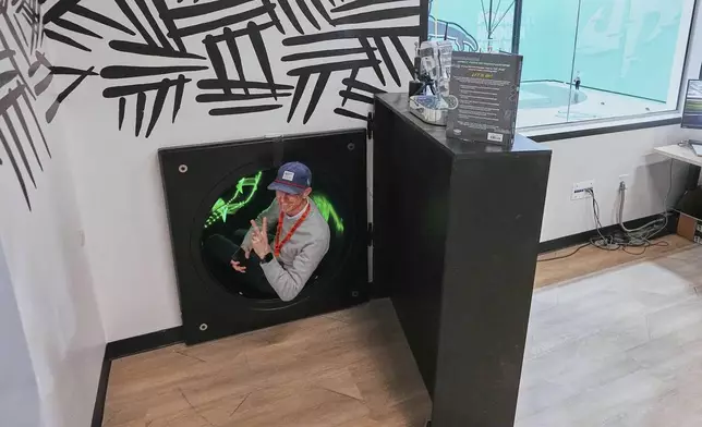 Visitor Andrew Harper gives a peace sign up in a hidden entrance before descending down a slide on the top floor of Dude Perfect's new headquarters in Frisco, Texas, Wednesday, Feb. 19, 2025. (AP Photo/Tony Gutierrez)