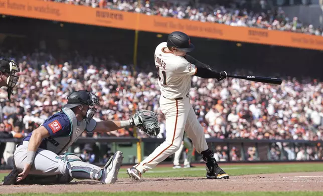 San Francisco Giants' Wilmer Flores, right, hits the the winning RBI single against the Seattle Mariners during the ninth inning of a baseball game in San Francisco, Sunday, April 6, 2025. (AP Photo/Kavin Mistry)