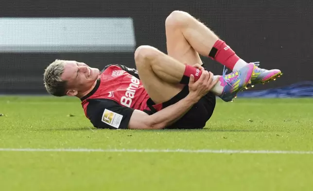 Leverkusen's Florian Wirtz lies on the pitch in pain during the German Bundesliga soccer match between Bayer Leverkusen and Union Berlin at the BayArena in Leverkusen, Germany, Saturday, April 12, 2025. (AP Photo/Martin Meissner)