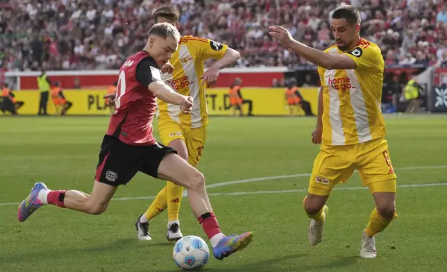 Leverkusen's Florian Wirtz, left, in action during the German Bundesliga soccer match between Bayer Leverkusen and Union Berlin at the BayArena in Leverkusen, Germany, Saturday, April 12, 2025. (AP Photo/Martin Meissner)