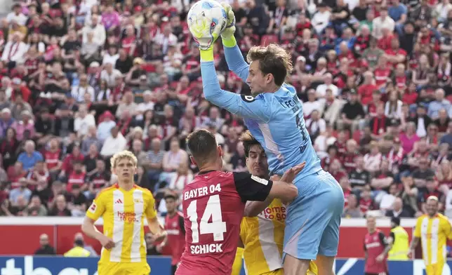 Union's goalkeeper Frederik Ronnow makes a save ahead of Leverkusen's Patrik Schick during the German Bundesliga soccer match between Bayer Leverkusen and Union Berlin at the BayArena in Leverkusen, Germany, Saturday, April 12, 2025. (AP Photo/Martin Meissner)