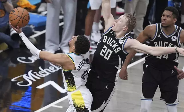 Milwaukee Bucks guard AJ Green (20) fouls Indiana Pacers guard Tyrese Haliburton (0) as he shoots during overtime in Game 5 of an NBA basketball first-round playoff series in Indianapolis, Tuesday, April 29, 2025. (AP Photo/Michael Conroy)