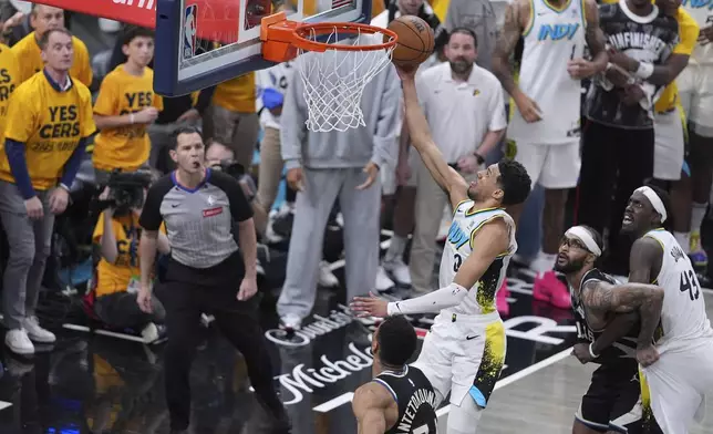 Indiana Pacers guard Tyrese Haliburton (0) shoots the game winning basket over Milwaukee Bucks forward Giannis Antetokounmpo, left, and guard Gary Trent Jr., right, during overtime in Game 5 of an NBA basketball first-round playoff series in Indianapolis, Tuesday, April 29, 2025. (AP Photo/Michael Conroy)