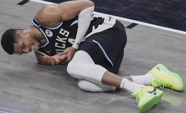 Milwaukee Bucks forward Giannis Antetokounmpo reacts after hitting his hand on the rim of the basket during the second half in Game 5 of an NBA basketball first-round playoff series against the Indiana Pacers, in Indianapolis, Tuesday, April 29, 2025. (AP Photo/Michael Conroy)