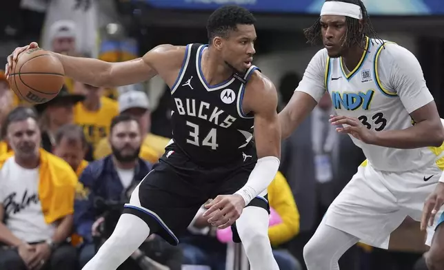 Milwaukee Bucks forward Giannis Antetokounmpo (34) dribbles the ball against Indiana Pacers center Myles Turner (33) during the second half in Game 5 of an NBA basketball first-round playoff series in Indianapolis, Tuesday, April 29, 2025. (AP Photo/Michael Conroy)