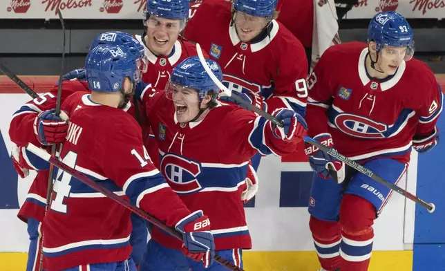 Montreal Canadiens' Cole Caufield, centre, celebrates with teammates after their win against the Carolina Hurricanes during third period NHL hockey action in Montreal on Wednesday, April 16, 2025. (Christinne Muschi/The Canadian Press via AP)