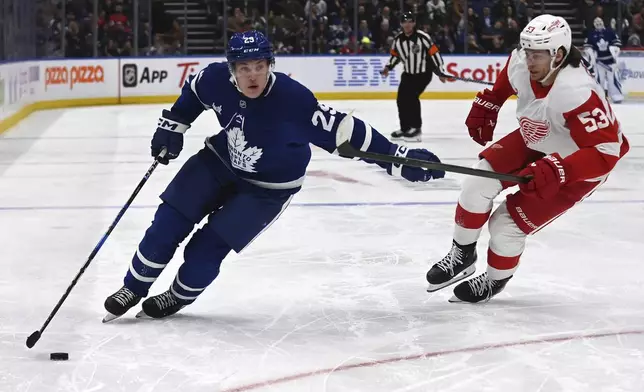 Toronto Maple Leafs' Pontus Holmberg (29) moves the puck around Detroit Red Wings' Moritz Seider (53) during the second period of an NHL hockey game Thursday, April 17, 2025, in Toronto. (Jon Blacker/The Canadian Press via AP)