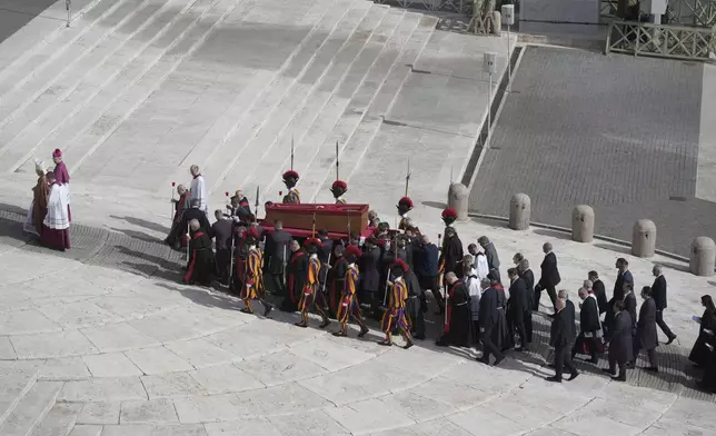 The body of Pope Francis is carried through St. Peter's Square to St. Peter's Basilica at the Vatican, Wednesday, April 23, 2025, where he will lie in state for three days. (AP Photo/Markus Schreiber)