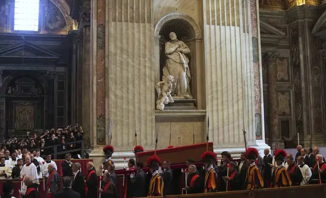 The procession with the body of Pope Francis, who will lie in state for three days, moves past the statue of Saint Philip Neri as it enters St. Peter's Basilica at the Vatican, Wednesday, April 23, 2025. (AP Photo/Francisco Seco)