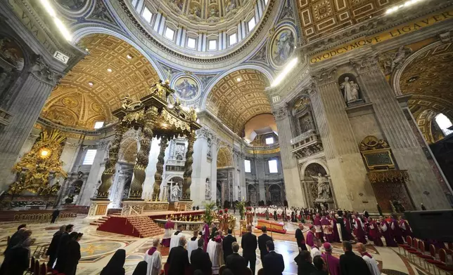 The procession over the body of Pope Francis inside St. Peter's Basilica at the Vatican, Wednesday, April 23, 2025, where he will lie in state for three days. (AP Photo/Alessandra Tarantino)