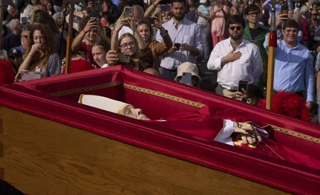 The body of Pope Francis is carried into St. Peter's Basilica at the Vatican, Wednesday, April 23, 2025, where he will lie in state for three days. (AP Photo/Emilio Morenatti)