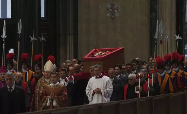 The procession with the body of Pope Francis, who will lie in state for three days, enters St. Peter's Basilica at the Vatican, Wednesday, April 23, 2025. (AP Photo/Francisco Seco)
