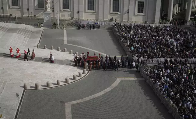 The body of Pope Francis is carried through St. Peter's Square to St. Peter's Basilica at the Vatican, Wednesday, April 23, 2025, where he will lie in state for three days. (AP Photo/Markus Schreiber)