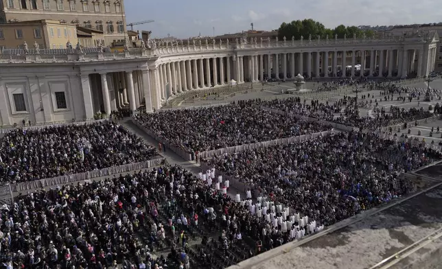 People watch in St. Peter's Square the procession of the arrival of the body of Pope Francis, who will lie in state at St. Peter's Basilica for three days, at the Vatican, Wednesday, April 23, 2025. (AP Photo/Gregorio Borgia)