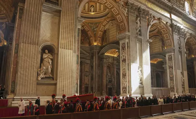 The procession with the body of Pope Francis, who will lie in state for three days, enters St. Peter's Basilica at the Vatican, Wednesday, April 23, 2025. (AP Photo/Francisco Seco)