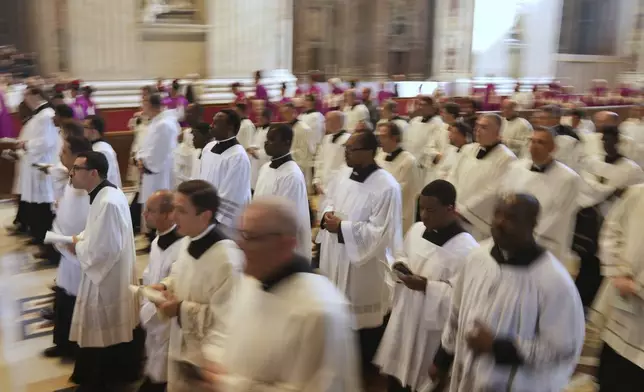 Clergymen follow the procession with the body of Pope Francis, who will lie in state for three days, entering St. Peter's Basilica at the Vatican, Wednesday, April 23, 2025. (AP Photo/Francisco Seco)