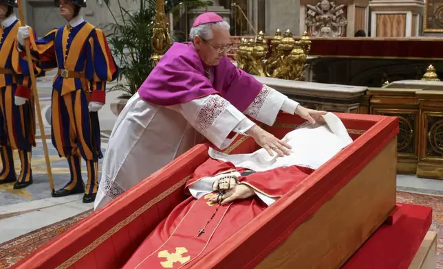 Vatican Master of Ceremonies Archbishop Diego Giovanni Ravelli covers the face of late Pope Francis with a silk cloth before closing his casket in St. Peter's Basilica at the Vatican Friday, April 25, 2025. (Vatican Media via AP)