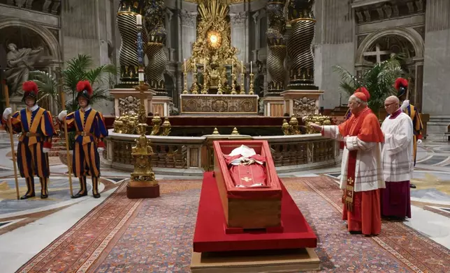 Cardinal Camerlengo Kevin Joseph Farrel, right, asperges the body of late Pope Francis with holy water before closing his casket in St. Peter's Basilica at the Vatican Friday, April 25, 2025. (Vatican Media via AP)