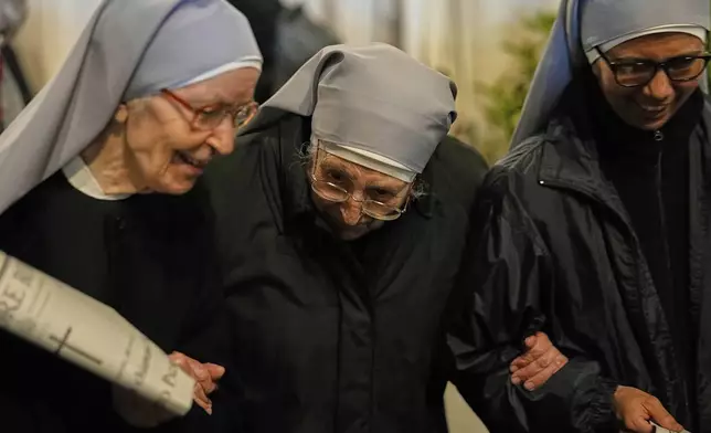 Nuns support each other as they leave after attending a rosary prayer outside the Santa Maria Maggiore Basilica, where the late Pope Francis will be buried, in Rome, Thursday, April 24, 2025. (AP Photo/Andreea Alexandru)