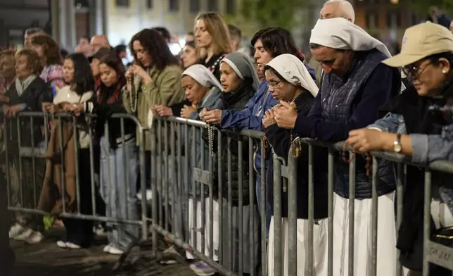 People attend a rosary prayer outside the Santa Maria Maggiore Basilica, where the late Pope Francis will be buried, in Rome, Thursday, April 24, 2025. (AP Photo/Andreea Alexandru)