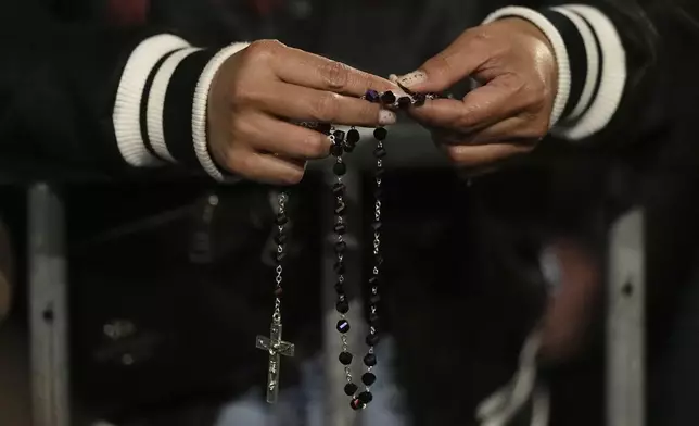 People attend a rosary prayer outside the Santa Maria Maggiore Basilica, where the late Pope Francis will be buried, in Rome, Thursday, April 24, 2025. (AP Photo/Andreea Alexandru)
